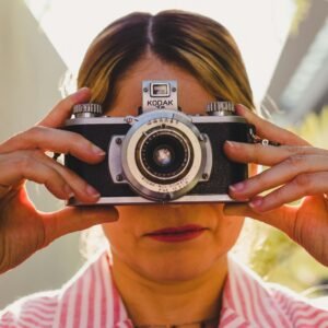 Photo d"une femme qui nous regarde a travers la lentille d'un appareil photo vintage Photo d"une femme qui nous regarde a travers la lentille d'un appareil photo vintage